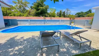 a swimming pool with a table and two chairs next to it at The Memories Hill Phuket in Thalang