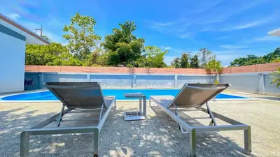 two chairs in front of a swimming pool at The Memories Hill Phuket in Thalang