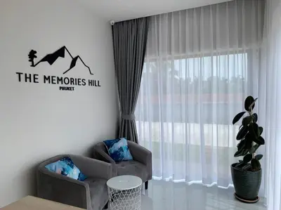 a living room with a chair and a window at The Memories Hill Phuket in Thalang