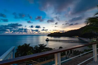 a view of a beach at sunset with a pier at Villa Serenity pool SeaView 6BR in Kamala Beach