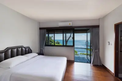 a bedroom with a bed and a view of the ocean at Villa Serenity pool SeaView 6BR in Kamala Beach