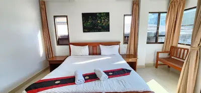 a bedroom with a bed and two windows at Royal Sweet Hotel in Patong Beach