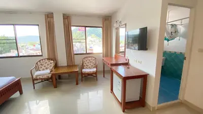 a room with a table and chairs and a television at Royal Sweet Hotel in Patong Beach