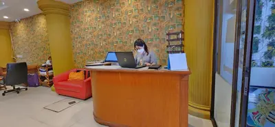 a woman standing at a counter with a laptop computer at Royal Sweet Hotel in Patong Beach