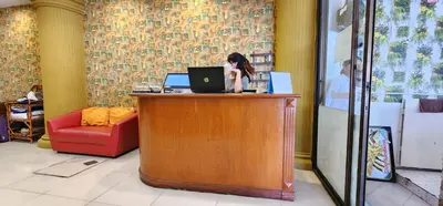 a woman sitting at a desk with a laptop computer at Royal Sweet Hotel in Patong Beach