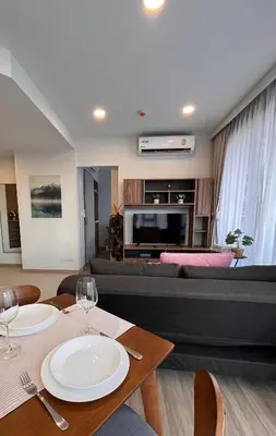 a living room with a table and a couch at 1 Bedroom Sky Park corner in Bang Tao Beach
