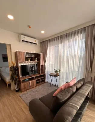 a living room with a couch and a large window at 1 Bedroom Sky Park corner in Bang Tao Beach