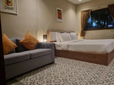 a hotel room with a bed and a couch at New Breakers Hotel Rawai in Rawai Beach