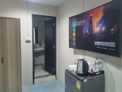 a bathroom with a flat screen tv on the wall at New Breakers Hotel Rawai in Rawai Beach