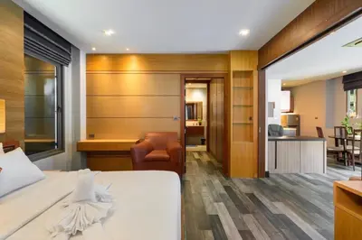 a hotel room with a bed and a living room at Villa Pattara Rawai in Ban Saiyuan (1)