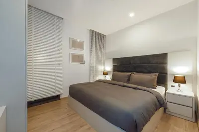 a bedroom with a large bed and two windows at Baan Mai Khao apartments Phuket in Mai Khao Beach