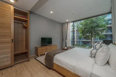 a bedroom with a bed and a large window at Baan Mai Khao apartments Phuket in Mai Khao Beach