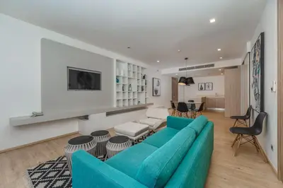 a living room with a blue couch and chairs at Baan Mai Khao apartments Phuket in Mai Khao Beach