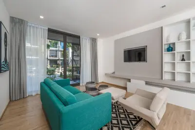a living room with a blue couch and chairs at Baan Mai Khao apartments Phuket in Mai Khao Beach