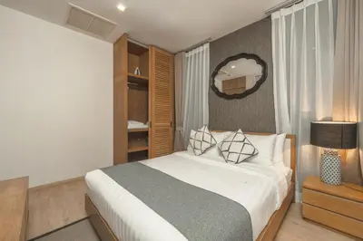 a bedroom with a bed and a mirror on the wall at Baan Mai Khao apartments Phuket in Mai Khao Beach