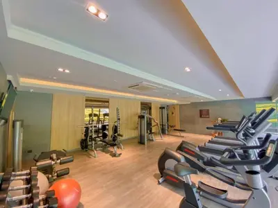 a gym with rows of treadmills and exercise equipment at Baan Mai Khao apartments Phuket in Mai Khao Beach