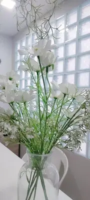 a vase filled with white flowers sitting on a table at Cinderella Residence in Patong Beach