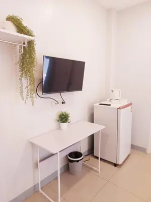a white desk with a tv on a wall at Cinderella Residence in Patong Beach