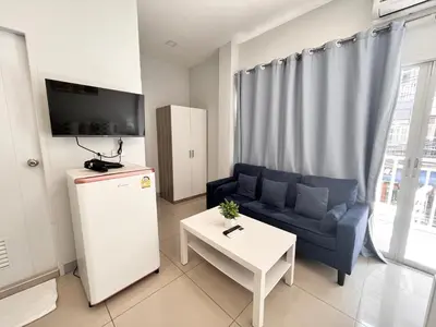 a living room with a blue couch and a table at Cinderella Residence in Patong Beach