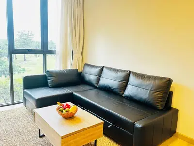 a black leather couch in a living room with a bowl of fruit at 1 Bdr Sky Park Golf view in Bang Tao Beach