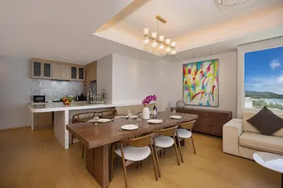 a kitchen and living room with a wooden table and chairs at Chic Design & Full Seaview 2BR Karon Condo 16C, near Beach in Karon Beach