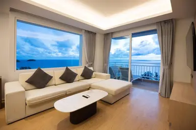 a living room with a white couch and large windows at Chic Design & Full Seaview 2BR Karon Condo 16C, near Beach in Karon Beach
