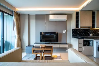 a living room with a couch and a table in a room at Deluxe apartment with sea view and jacuzzi in Surin Beach