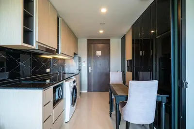 a kitchen with a table and a stove top oven at Deluxe apartment with sea view and jacuzzi in Surin Beach