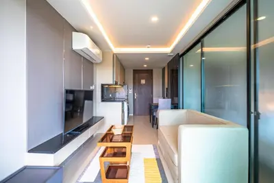 a kitchen and living room with a white refrigerator at Deluxe apartment with sea view and jacuzzi in Surin Beach
