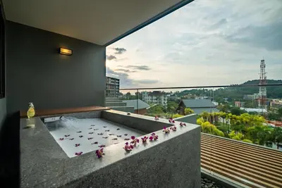 a group of pink flowers sitting on a balcony at Deluxe apartment with sea view and jacuzzi in Surin Beach