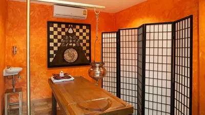 a room with a table and a wall with orange walls at Spacious apartment at Kata Ocean View M11 in Kata Beach