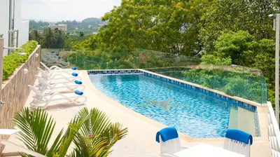 a swimming pool with chairs next to at Spacious apartment at Kata Ocean View M11 in Kata Beach
