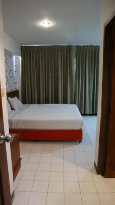 a bedroom with a bed and a window with curtains at Patong Triple P in Patong Beach