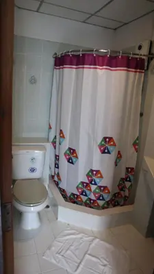 a bathroom with a toilet and a shower curtain at Patong Triple P in Patong Beach