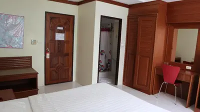 a bedroom with a bed and a desk and a closet at Patong Triple P in Patong Beach