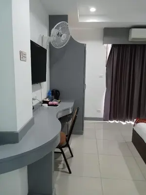 a room with a desk and a fan at T & C Hotel Patong Beach in Patong Beach