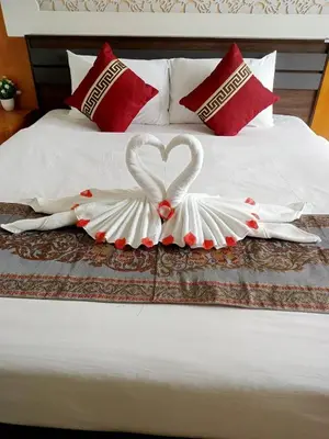 a bed with two swans made out of towels at T & C Hotel Patong Beach in Patong Beach