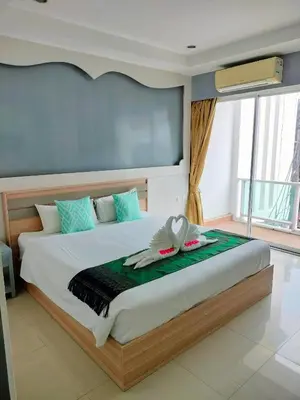 a bedroom with a large bed with towels on it at T & C Hotel Patong Beach in Patong Beach