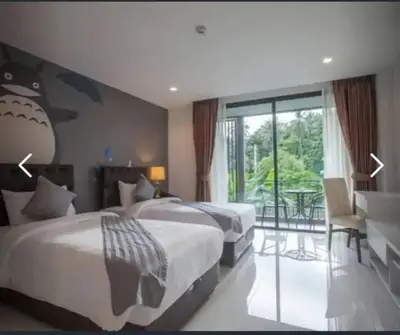 a hotel room with two beds and a balcony at Panwa Beach Side Beachfront in Panwa Beach