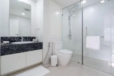 a white bathroom with a toilet and a glass shower at Patong Tower 1-Bedroom , 200 meters from the Beach in Patong Beach