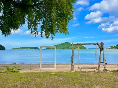 a swing on the beach with the ocean in the background at Secret Place in Panwa Beach
