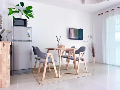 a kitchen with a table and chairs and a refrigerator at Secret Place in Panwa Beach
