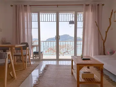 a living room with a bed and a large window at Secret Place in Panwa Beach