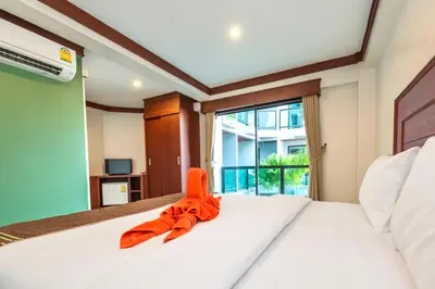 an orange ribbon sitting on a bed in a bedroom at Kata Noi Bay Inn in Kata Beach