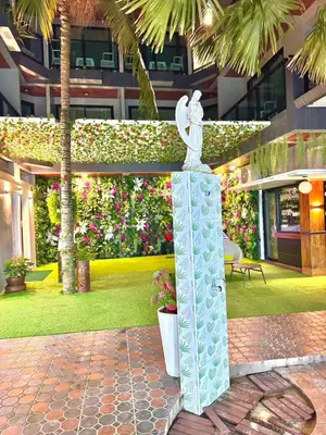 a statue of a bird on a stand in a courtyard at Kata Noi Bay Inn in Kata Beach