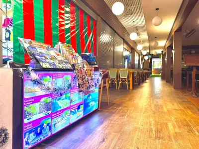 a store aisle with tables and chairs in a room at Kata Noi Bay Inn in Kata Beach