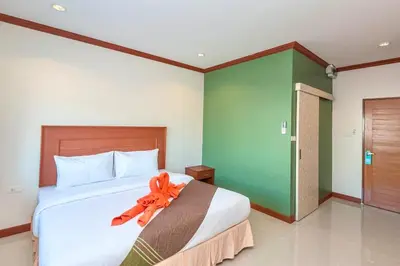 a bedroom with a large bed with an orange ribbon on it at Kata Noi Bay Inn in Kata Beach