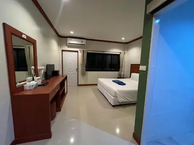 a bedroom with a bed and a desk and a mirror at Kata Noi Bay Inn in Kata Beach