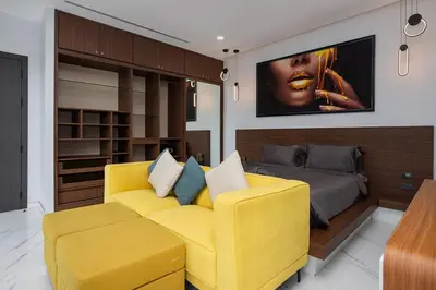 a living room with a yellow couch and a bed at Villa Brianna Luxuria 4 - Rawai in Rawai Beach