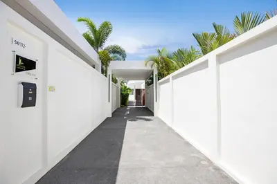a hallway of a house with white walls and palm trees at Villa Brianna Luxuria 4 - Rawai in Rawai Beach